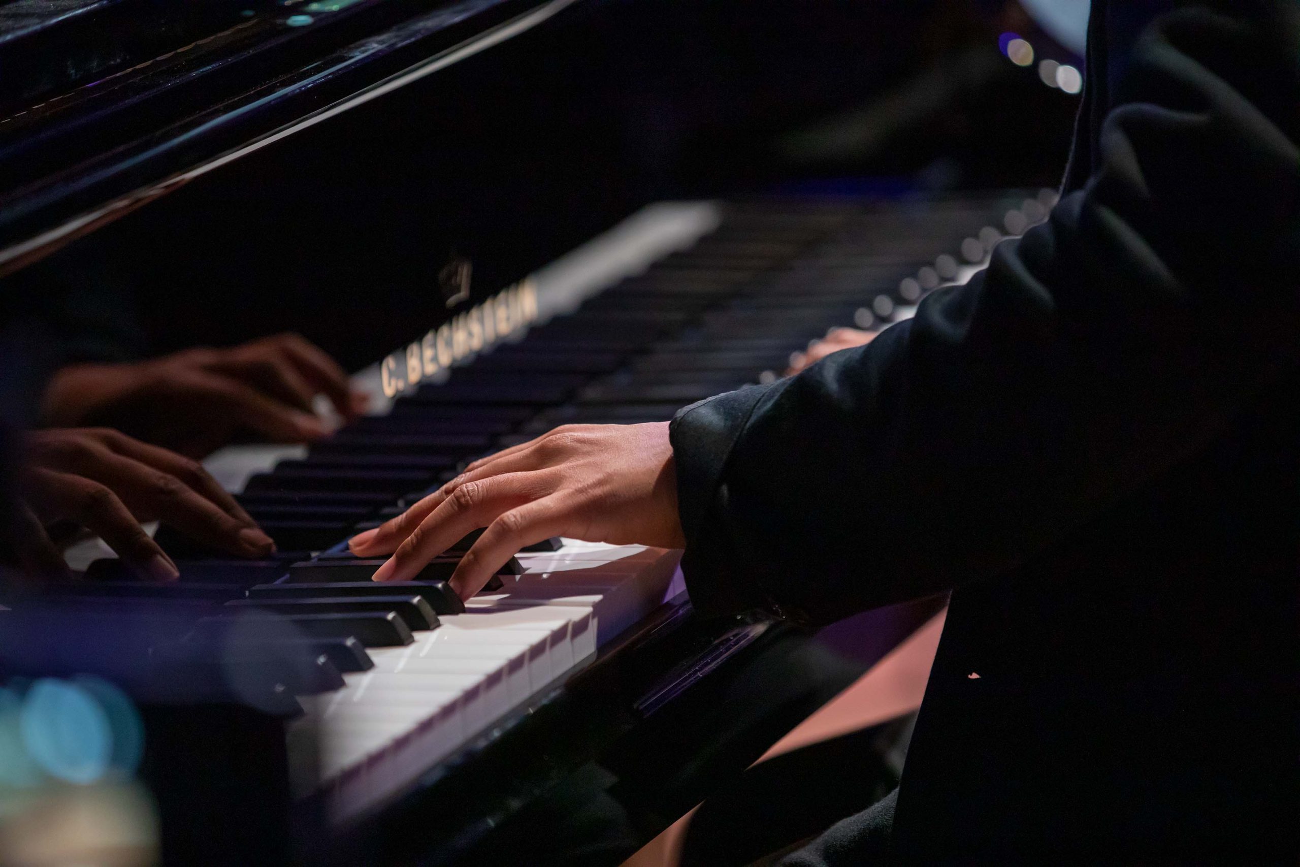 The two hands of Yannick Rafalimanana on a black C.Bechstein-Piano